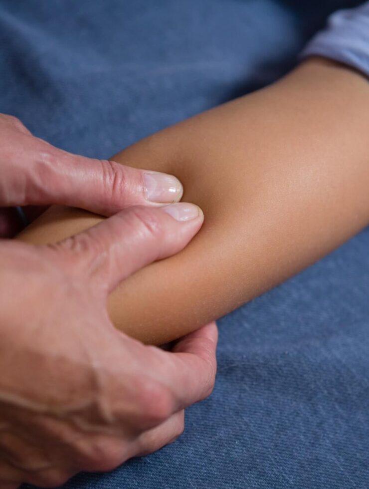 Physiotherapist giving hand massage to patient