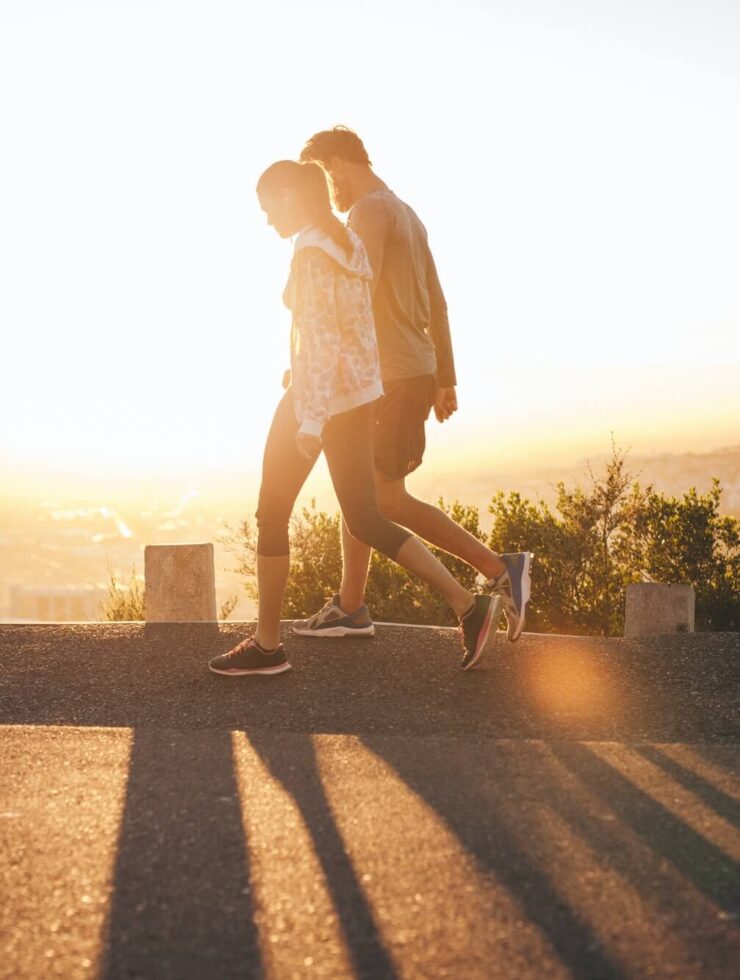 Couple walk along road at sunrise