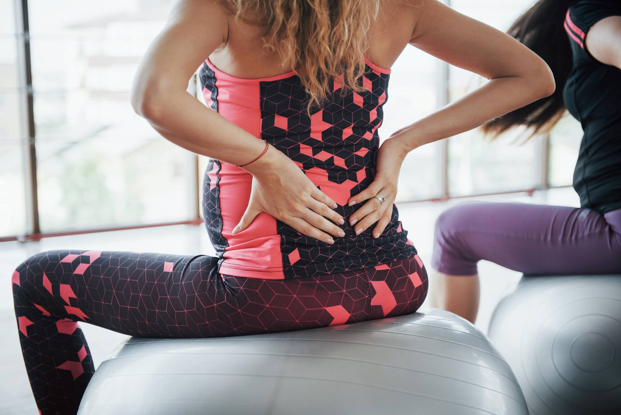 Young pregnant women sitting on the ball for exercises in the gym