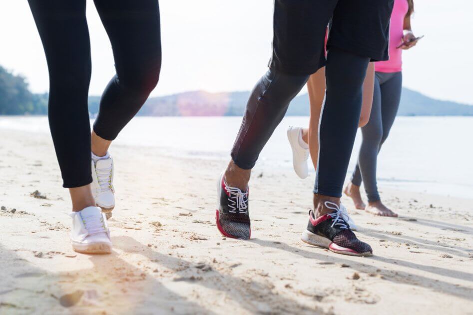 Closeup Of Group Of People Running On Beach Feet Shot Sport Runners Jogging Working Out Team Men And