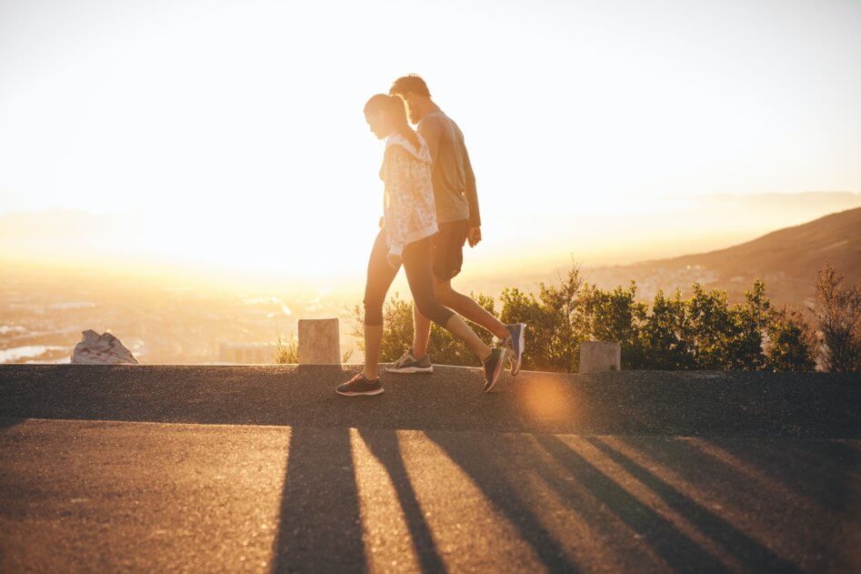 Couple walk along road at sunrise